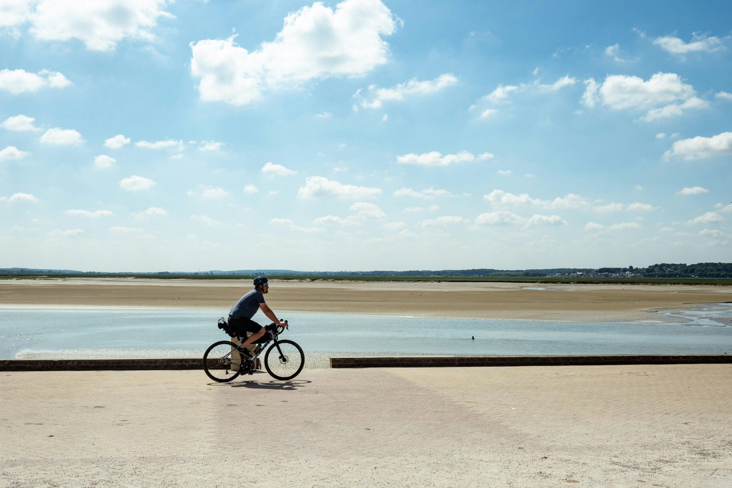 Ein Radfahrer genieÃt einen sonnigen Tag an der malerischen französischen Küste, perfekt für Abenteuer im Freien.